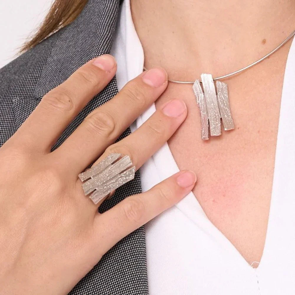 Eine Frau trägt einen Ring und Halskette aus der Kollektion "Adara"