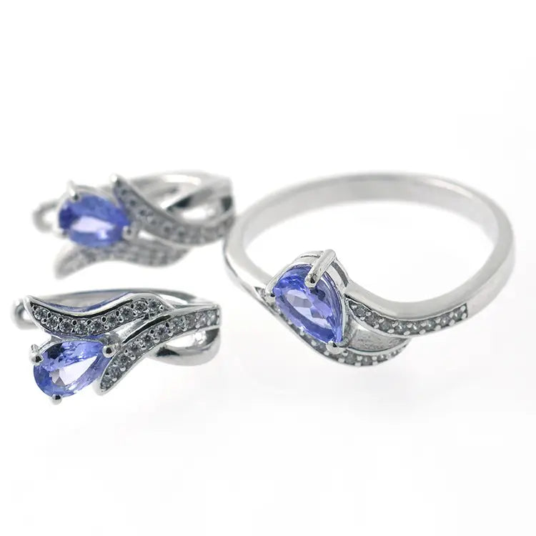 Mehrteiliges Schmuckset aus 925er Sterlingsilber mit edel gefassten Tansanit Edelsteinen in charakteristischem Blau-Violett, minimalistisches Design.