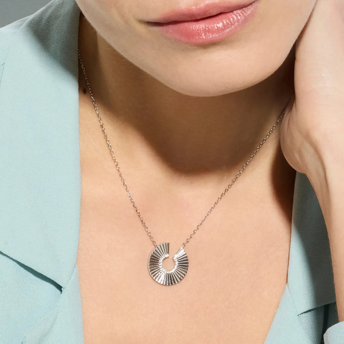 Filigrane Halskette aus rhodiniertem 925er Silber mit einem geometrischen, intensiv funkelnden Zirkonia-Anhänger am Dekolleté getragen