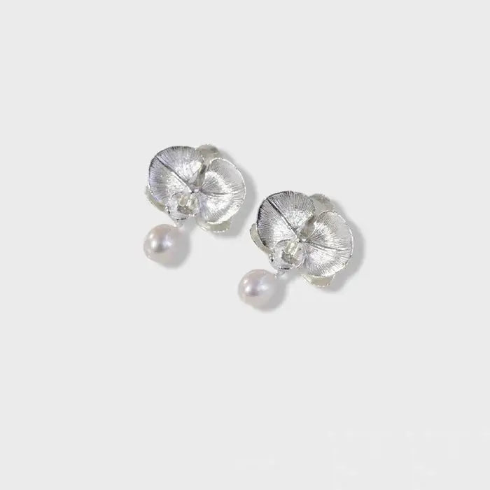 Filigrane Orchideen-Ohrringe aus Silber mit einem hängenden Perltropfen.