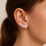 Filigraner Earclimber Ajana aus poliertem 925 Sterling Silber mit kleinen Kreisen an einem weiblichen Ohr getragen