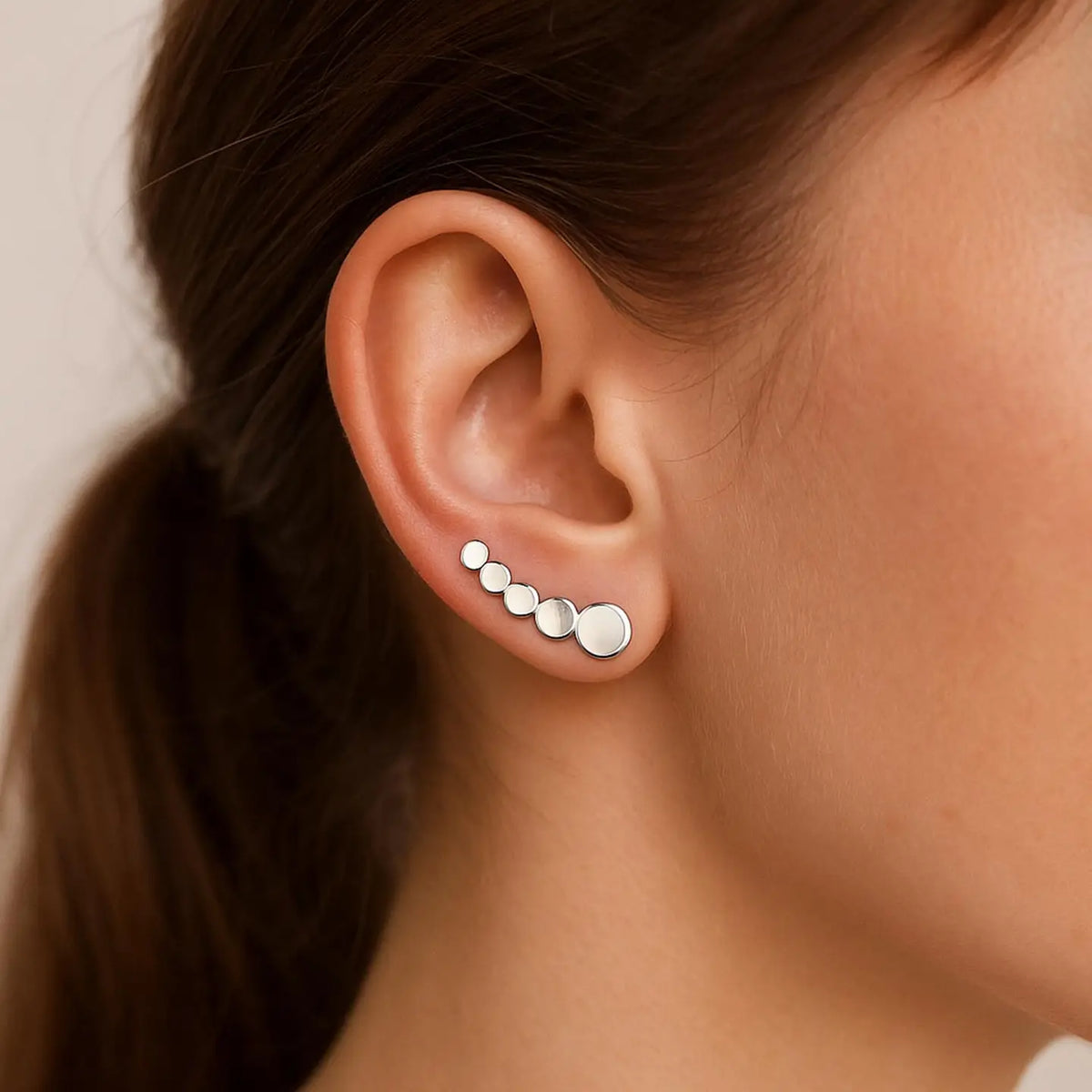 Filigraner Earclimber Ajana aus poliertem 925 Sterling Silber mit kleinen Kreisen an einem weiblichen Ohr getragen