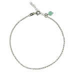 Zarte Fußkette aus rhodiniertem 925er Silber mit einer kleinen, hellgrünen Chalcedon-Edelsteinkugel am Knöchel getragen