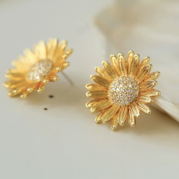 Vergoldete Damen-Ohrstecker mit großem Sonnenblumenmotiv und schillernd glitzernden Steinen in Handarbeit.