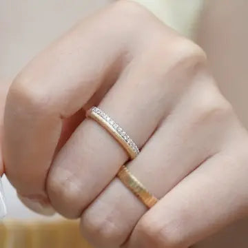 Ein einzelner breiter Schicht-Ring aus glänzendem Metall in modernem Multi-Layer-Design mit übereinanderliegenden Linien.