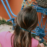 Die schlanke, französische Haarspange Louise aus glänzendem Baumwoll-Acetat, präsentiert in einer edlen Frisur.